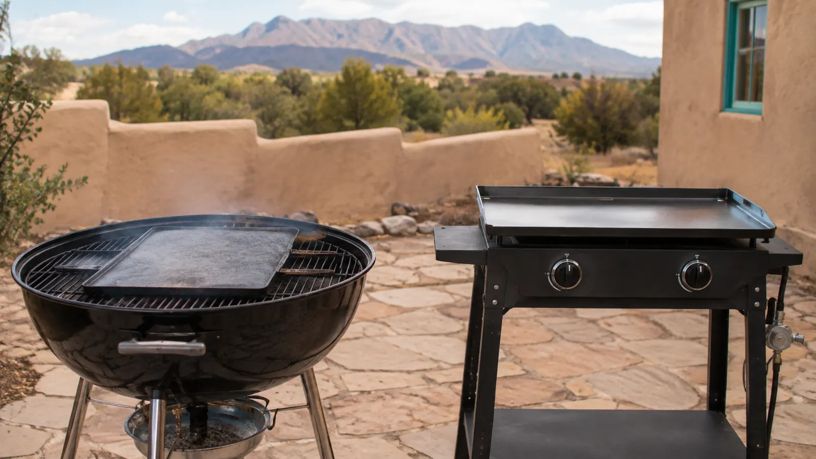 A cast iron griddle resting on a kettle grill next to a two-burner steel tabletop griddle station on a stone patio